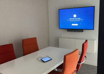 Small meeting room with a wall-mounted Samsung display, Neat video bar and touch panel